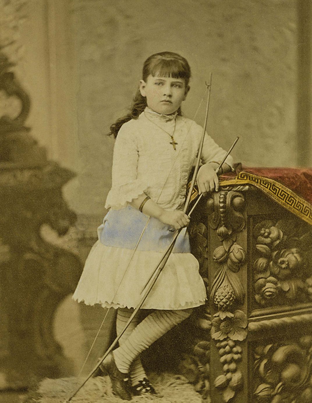 a vintage sepia toned photograph of a young girl standing