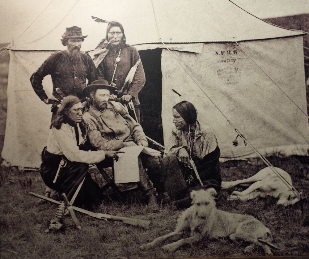Custer (seated, second from left) and a Native American scout named Bloody Knife (kneeling at left)