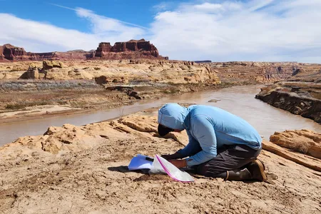 Returning Rapids Project investigator Chris Benson examines old photos of the Colorado River to see how it has changed over time.