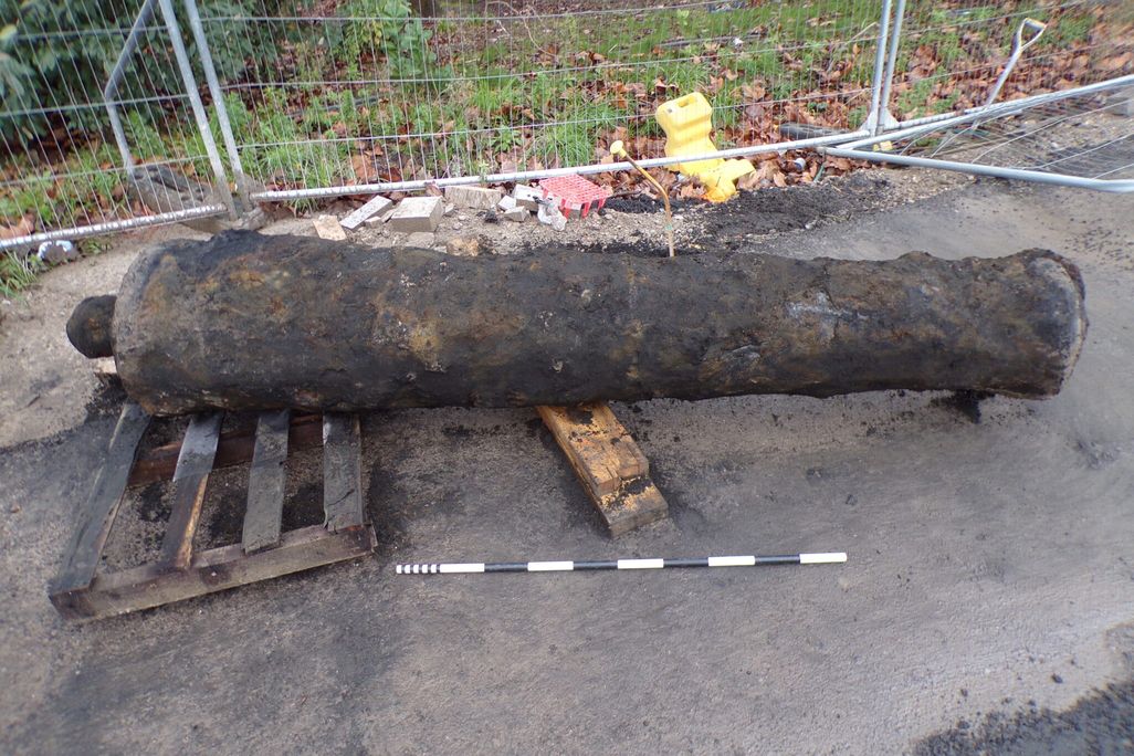 A dirty cannon sitting on the ground
