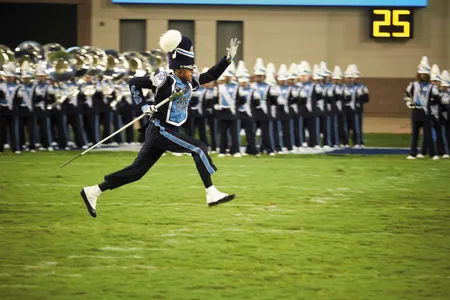 A Sonic Boom drum major dashes across the field.