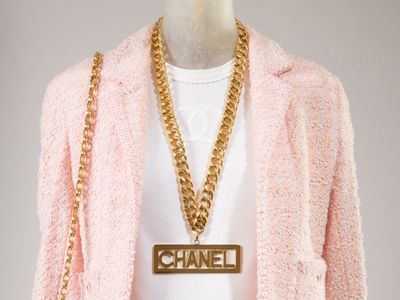 Chanel (Karl Lagerfeld), suit, pink wool and synthetic blends, white cotton, spring 1994, France, gift of Chanel Inc. Chanel (Karl Lagerfeld), necklace, gold plated metal, fall 1991, France, Gift of Depuis 1924.