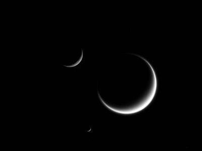 The Cassini spacecraft took this image of three of Saturn's moons, Rhea, Mimas and Titan. 