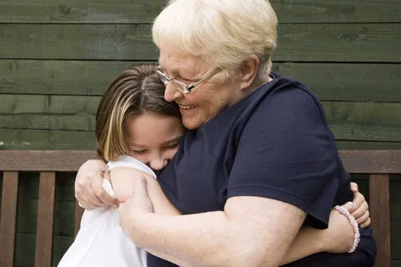 A woman hugs her granddaughter. Some scientists believe child care from grandmothers influenced human evolution.