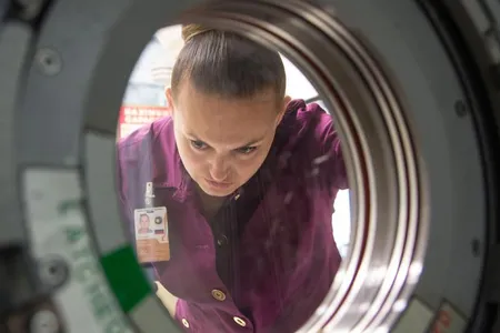 Elena Serova looks through a hatch outside a space station training mockup in Houston last October.