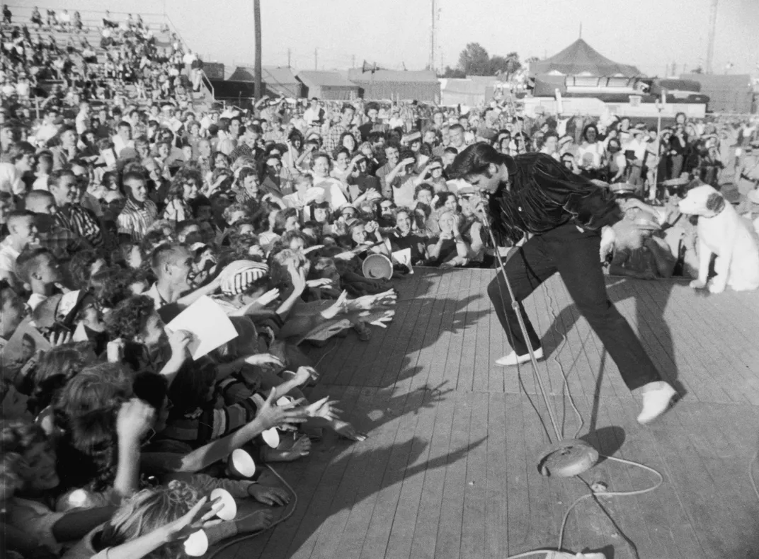 Elvis performing in front of a crowd around 1957