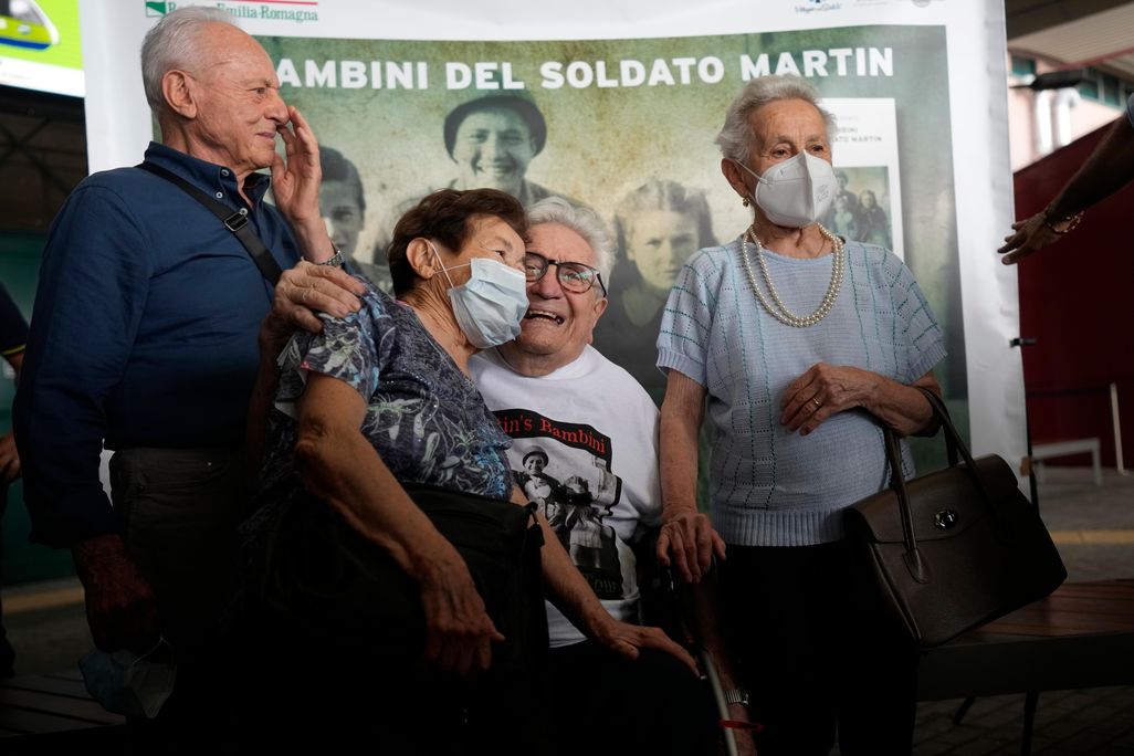 Adler sits in a wheelchair, center, embracing Mafalda, while Bruno and Giuliana smile and pose on either side