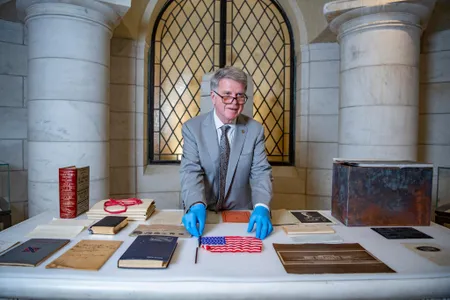Archivist of the United States David S. Ferriero displays historical objects recovered from the Arlington National Cemetery time capsule. 