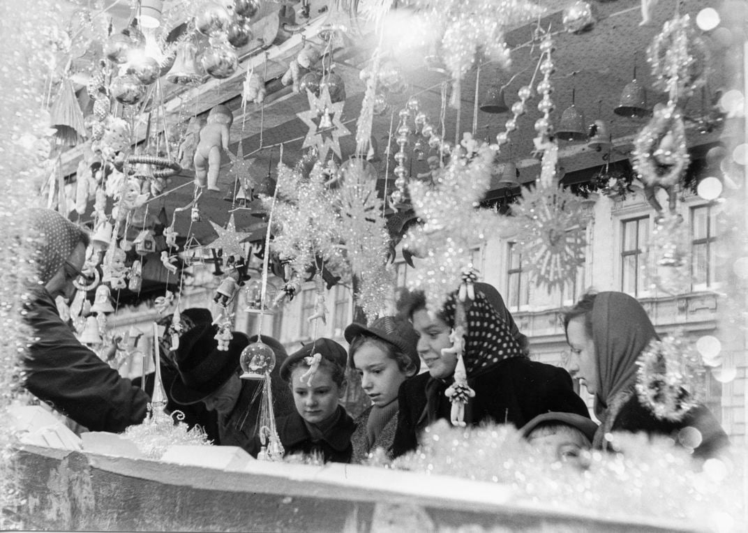 Shoppers admire holiday decorations on sale at a Christmas market in Vienna, Austria, on December 19, 1953.