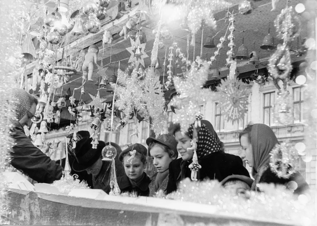 Shoppers admire holiday decorations on sale at a Christmas market in Vienna, Austria, on December 19, 1953.