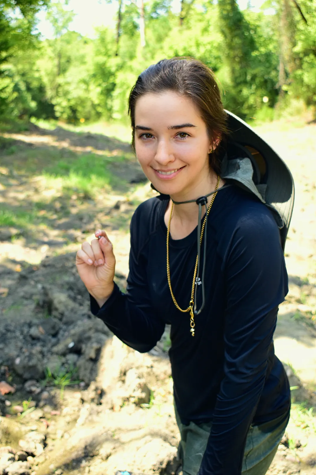 Brunette woman holding up a tiny diamond