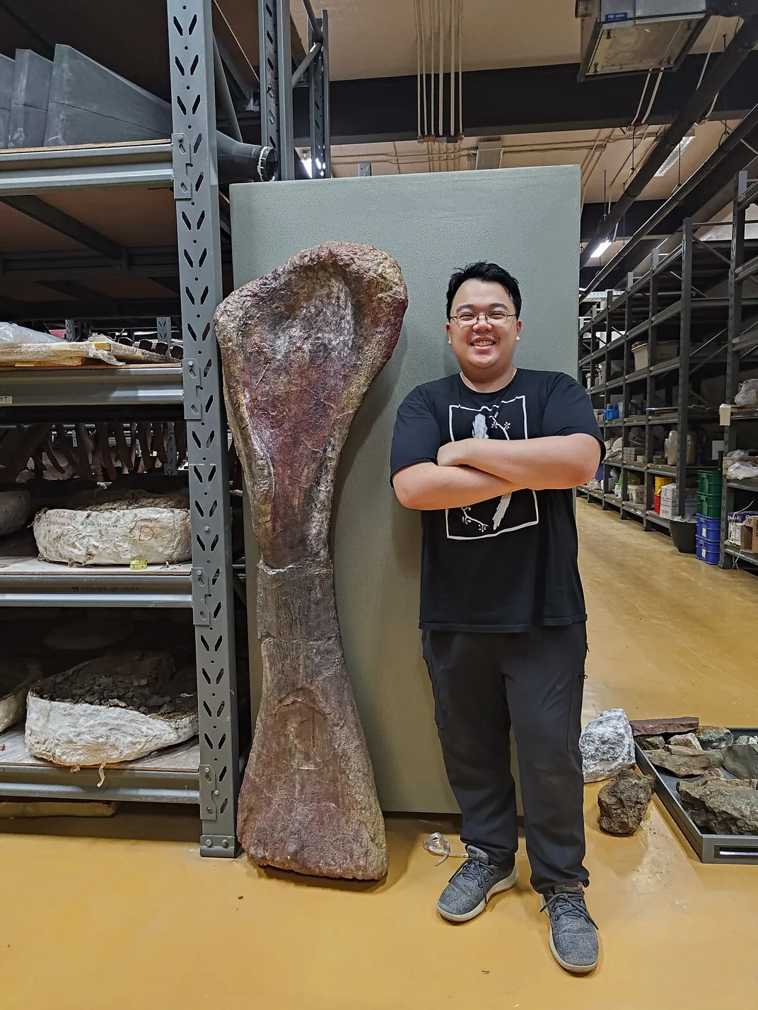 A man standing next to a very large bone