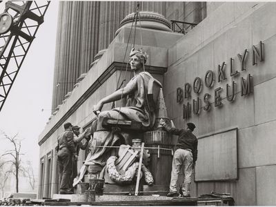 The statue Brooklyn by Daniel Chester French being hoisted at the Brooklyn Museum in 1964