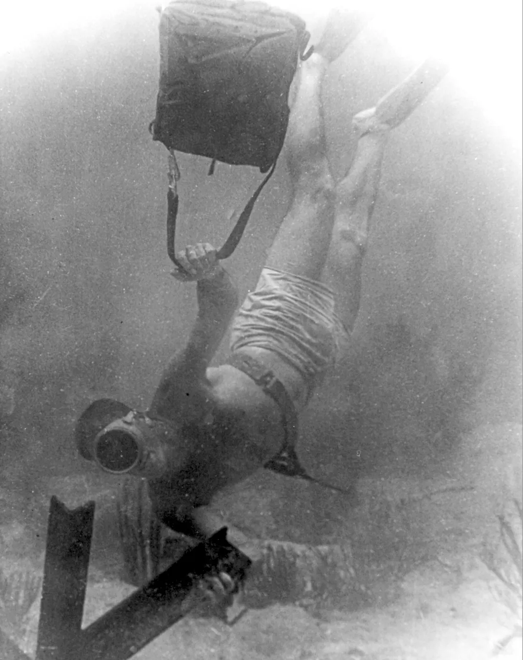 A UDT member attaching explosives to an underwater obstacle