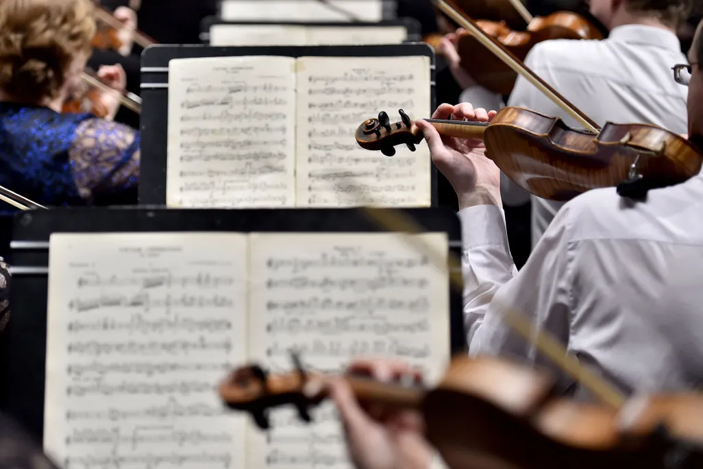 A row of musicians in front of sheet music