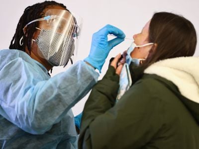 A person receives a Covid-19 nasopharyngeal swab at a testing site in Los Angeles International Airport on December 21, 2021.&nbsp;