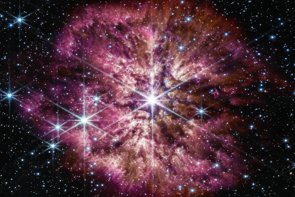 Purple and pink nebular surrounding bright white star against dark background