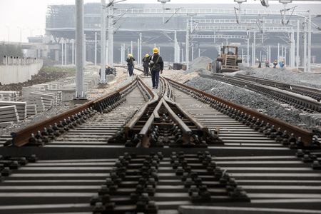 Workers lay railway tracks near the new railway station in Shanghai, China on 01 March 2010.