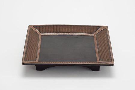 The dark black lacquered center of the Ming Dynasty tray, surrounded by an elegant basket weave design, made it seem almost modern.