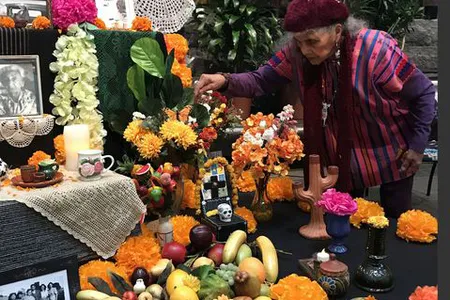 Doña Ofelia Esparza decorates the ofrenda "Sacred Connections," created with her daughter Rosanna Esparza Ahrens for the 2019 celebration of El Día de los Muertos—the Day of the Dead—at the National Museum of the American Indian in Washington. 