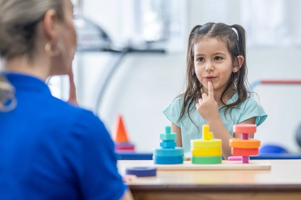 a young girl doing speech therapy