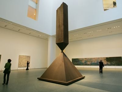 MoMA visitors walk around a sculpture by Barnett Newman titled Broken Obelisk.