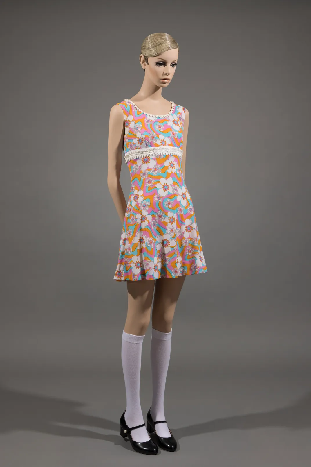 A Twiggy mannequin wearing a printed synthetic jersey dress from the model's fashion label