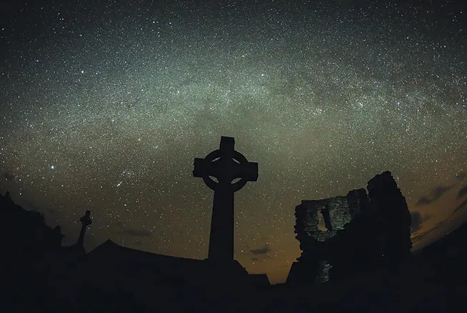 Night sky and a cross-shaped gravestone