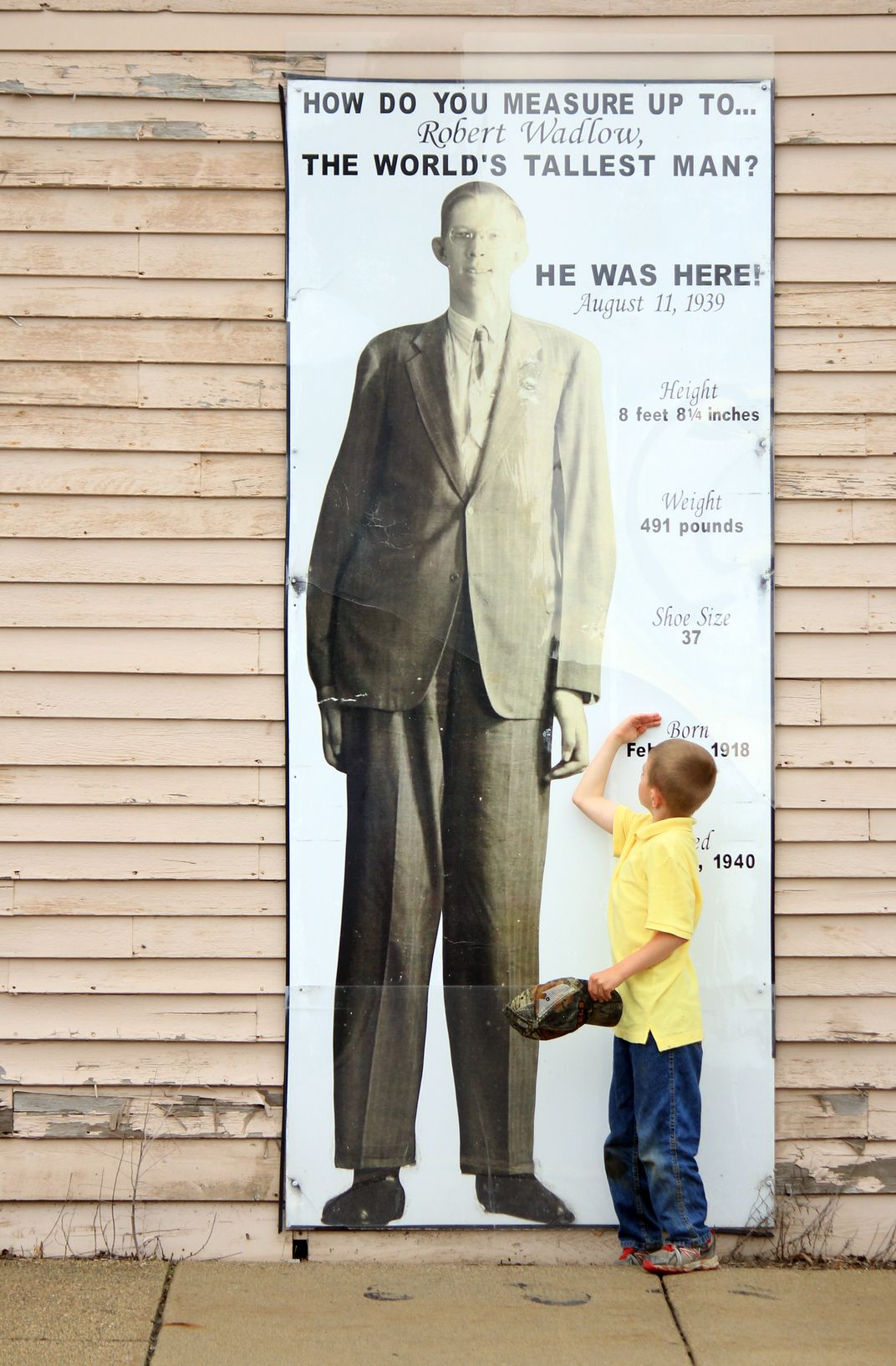 A Young Boy Measuring Himself Against The World s Tallest Man 