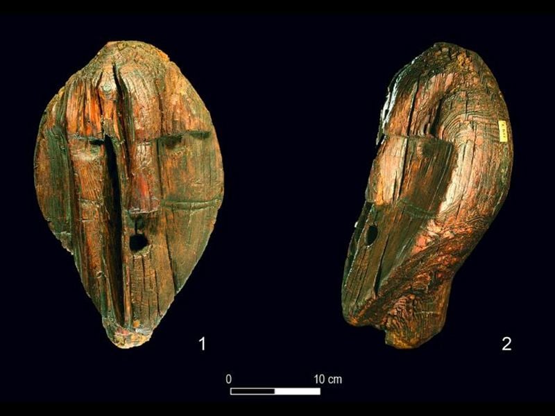 A selection of carved wooden faces and pieces of orange-ish wood carved with geometric patterns