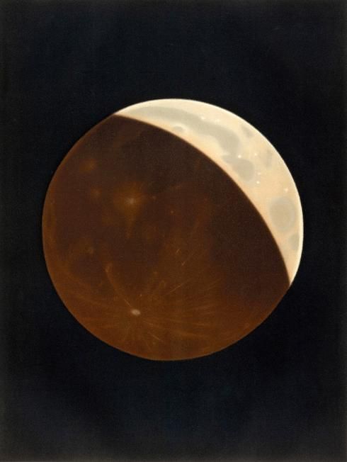 In this pastel drawing, three-quarters of the moon's surface is eclipsed. The eclipsed portion is portrayed in a dark orange-red color. The sliver of uneclipsed lunar surface is gray.
