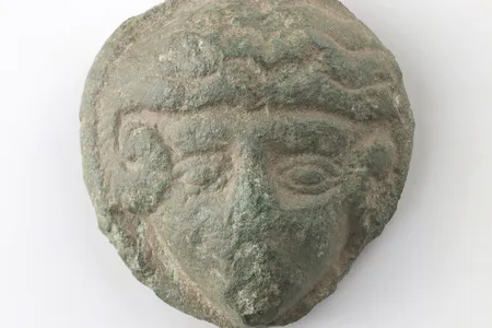 The newly discovered bronze disc depicts Alexander the Great with wavy hair and ram horns.