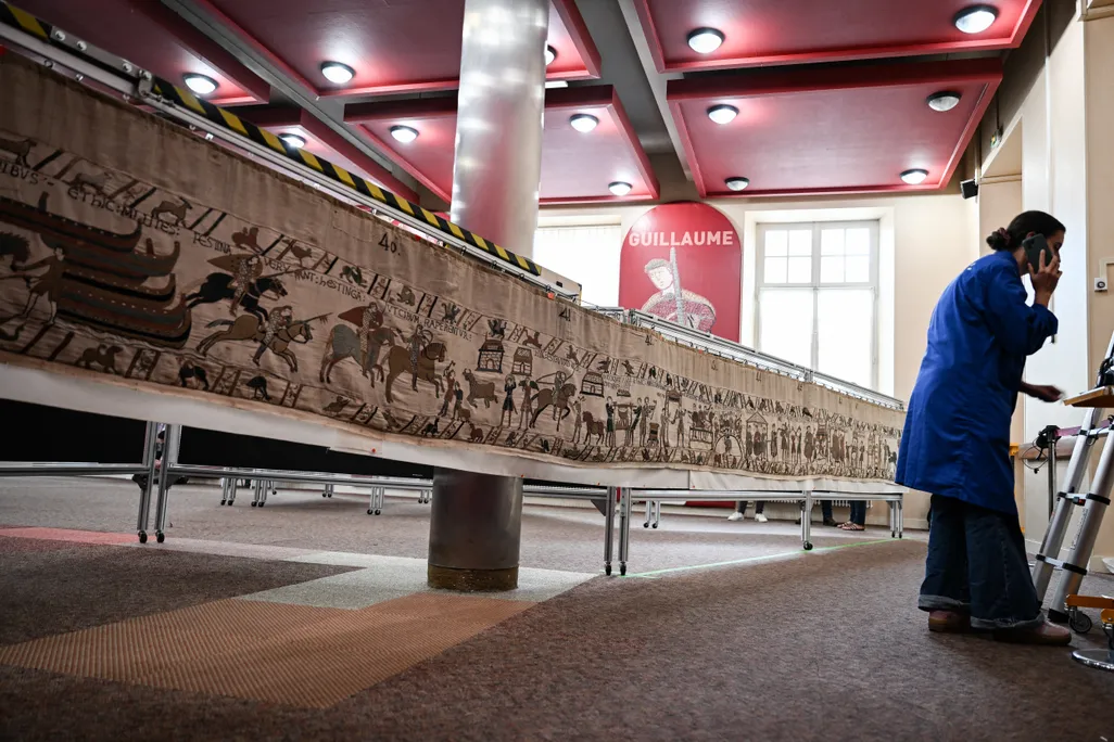 A long tapestry and a woman talking on a phone