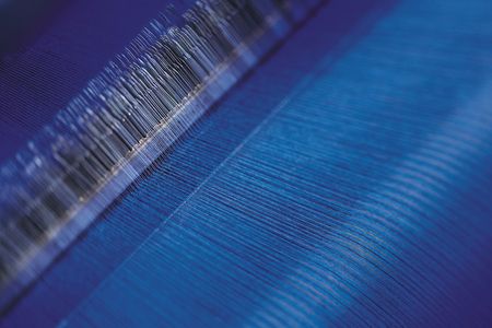 A close-up of fabric in a loom