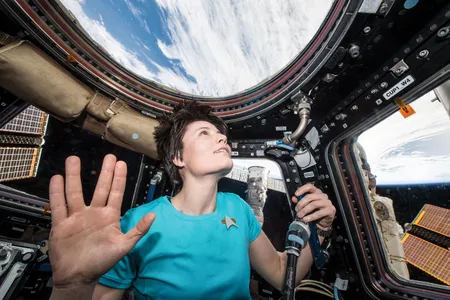 Samantha Cristoforetti gives a Vulcan salute to honor Leonard Nimoy after the actor’s death in February 2015. She has separately posted a photo of herself from the ISS in a Star Trek: Voyager uniform.