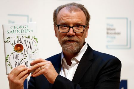 George Saunders poses with his book Lincoln in the Bardo, which won the 2017 Man Booker Prize for Fiction.