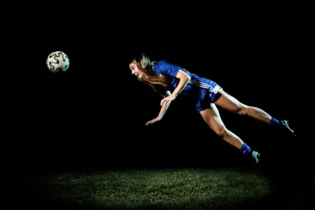 A high school soccer player remembers to keep her eye on the ball, even when soaring midair.

