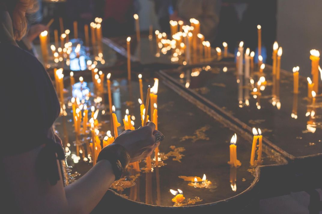 Burning candles in a church on a dark background
