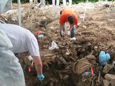 Workers examine remains at a mass grave in eastern Bosnia in 2004.