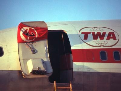 The Popular Front for the Liberation of Palestine&#39;s flag hangs on the door of a hijacked TWA Boeing 707 at Dawson&#39;s Field in Libya in September 1970.