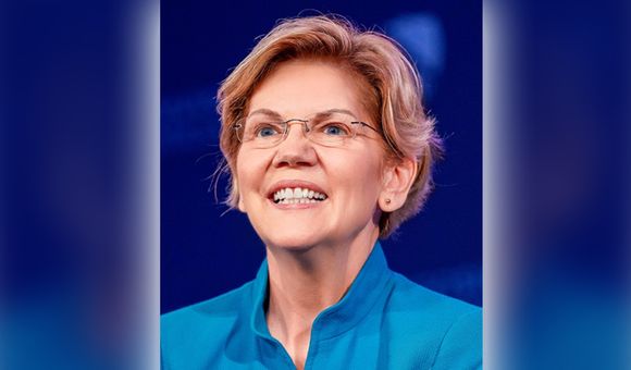 Image of a woman, Elizabeth Warren, smiling in a blue shirt