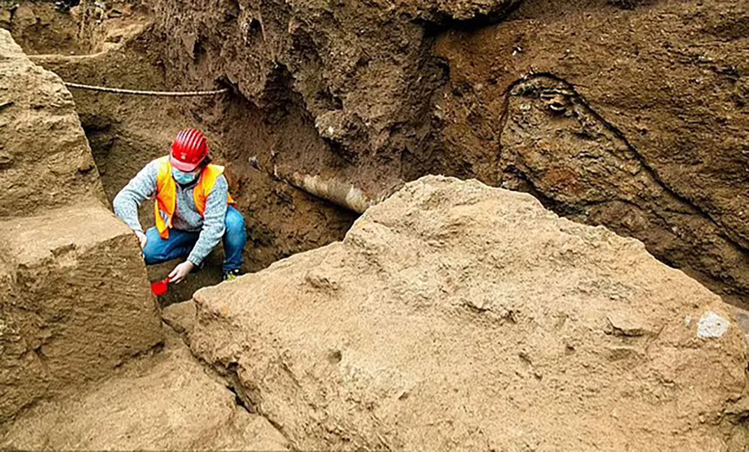 archaeologist working inside a trench of dug out burial site