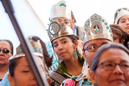 Audience members in the VIP section, including Miss Indian New Mexico Nicole Johnny, 25, center, look on during the butchering competition.