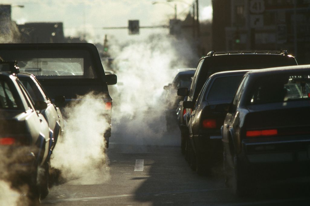 Smoke billows from two lines of cars' exhaust pipes