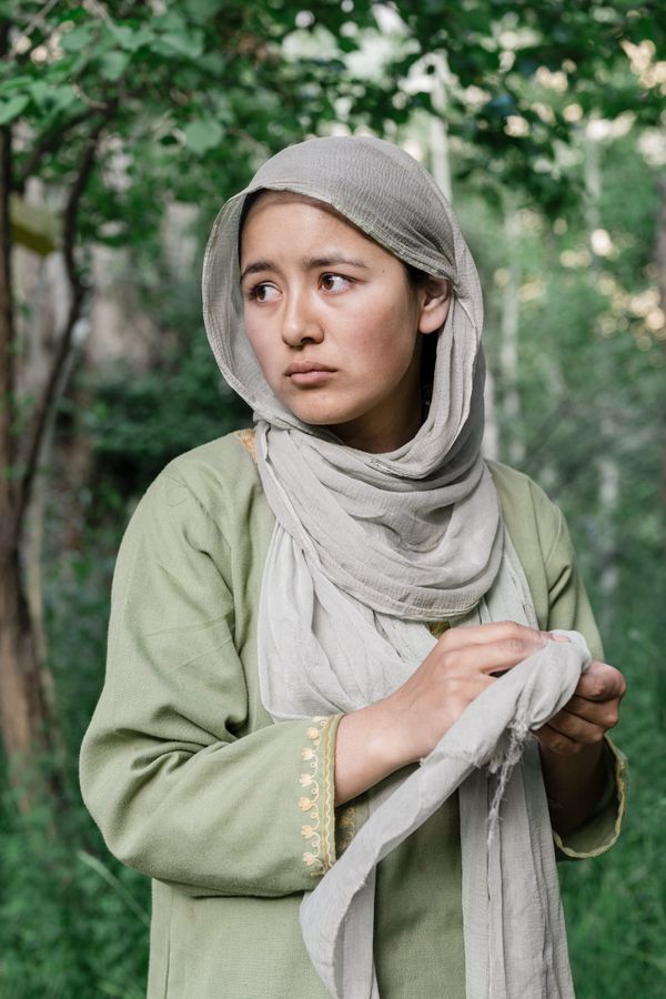 A portrait of a young Muslim woman under her family's apricot trees. thumbnail