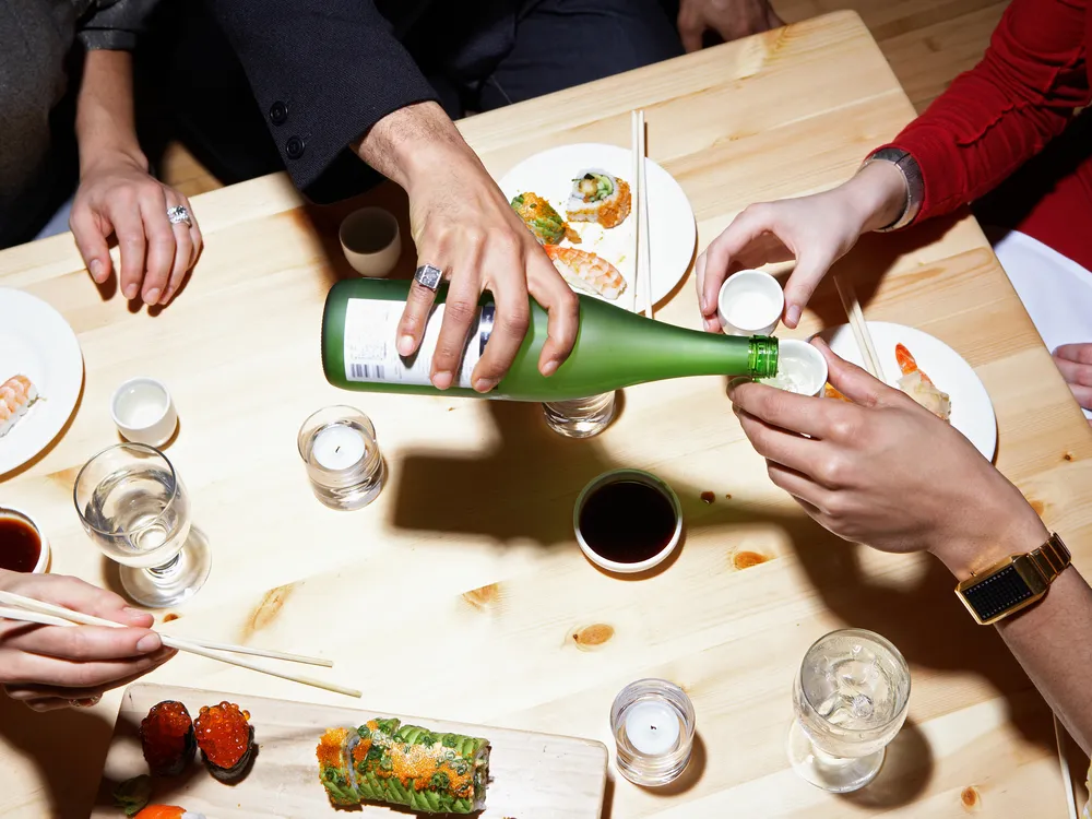 pouring sake at a table