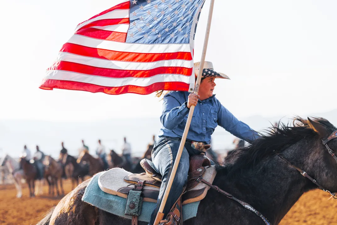 5 - A rider carries the flag during the opening ceremony at Williams Ranch Rodeo in Williams, Arizona.