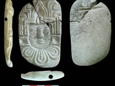 A carved pendant plaque of a human head found at the Ucanal burial site.