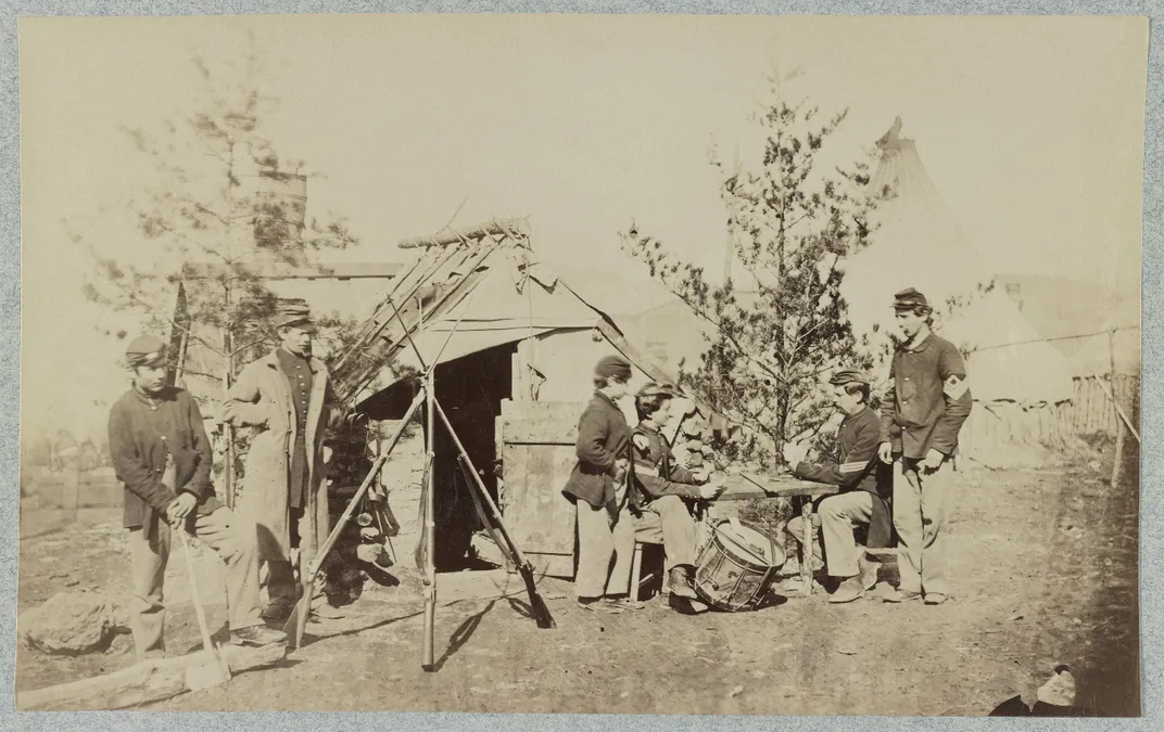 Off-duty drummer boys playing cards in camp in the winter of 1862