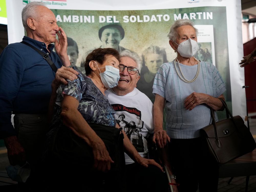 Adler sits in a wheelchair, center, embracing Mafalda, while Bruno and Giuliana smile and pose on either side